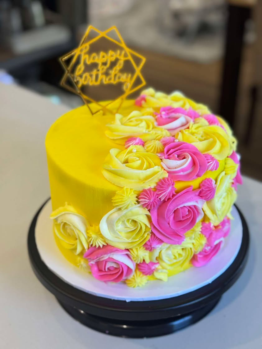 Yellow and pink rosette birthday cake with gold topper